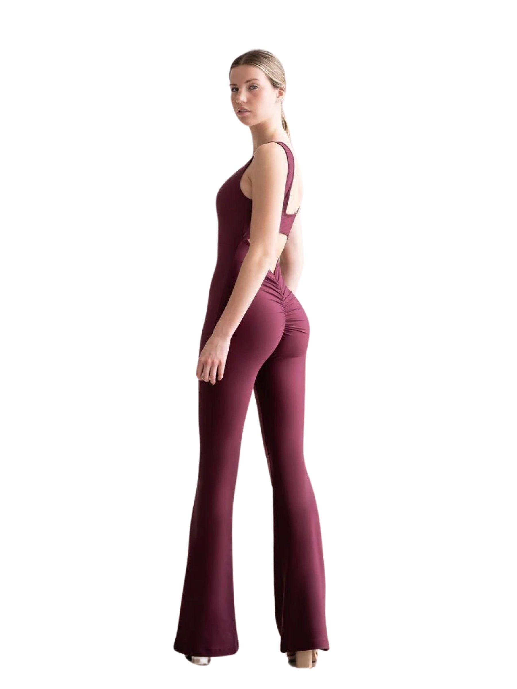 Person in dunkelviolettem Lisminas 1501 Spanish Scrunch Butt Jumpsuit, stehend auf weißem Hintergrund.